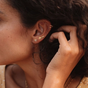 Close-up of golden eye and rose studs with sparkling zircon on model ear