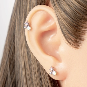 Elegant star-shaped stud earrings with rainbow zircon stones on model's ear