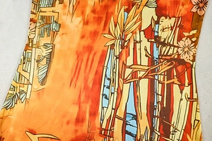 Detail view of artistic orange and blue bamboo floral print on woven fabric dress