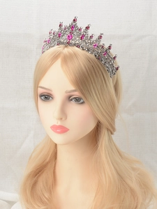 Detail of vintage crown tiara with pink gemstones and sparkling crystals on model