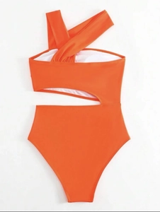 Detail of bright orange one-shoulder monokini featuring side cut-out and high-cut waist