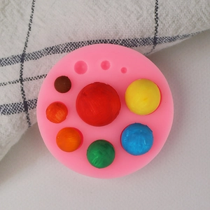 Pink silicone mold for round fondant pearls with colorful DIY cake decorations