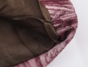 Detailed macro view of pink velvet corduroy fabric with dark brown twill inner lining