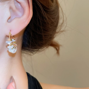 Detail shot of 18k gold plated geometric hoop earrings with crystals on a female model