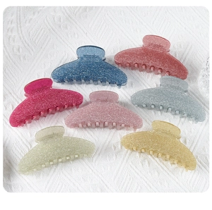 Detailed close-up of large glittery acrylic shark hair claws in multiple assorted colors