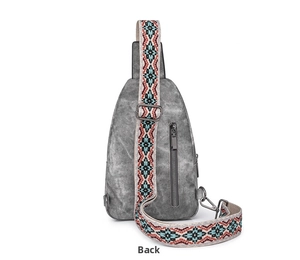 Detail of grey crossbody bag with vintage matte texture and ethnic embroidery strap