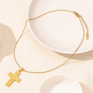 Detail view of 18K gold plated stainless steel cross pendant with floral relief patterns
