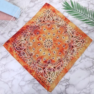 Detail of 100% cotton paisley bandana featuring orange and yellow flame pattern textures