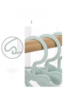 Detail of light green bow-shaped kids hanger with side hooks and non-slip design
