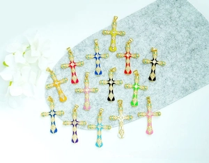 Detailed flat lay of 13 colorful enamel cross pendants with 18K gold plating and micro-inlays