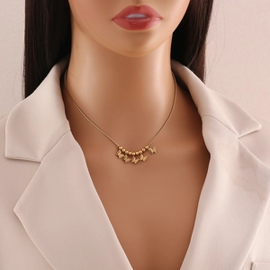 Elegant gold beaded butterfly necklace with multiple charms worn by a model