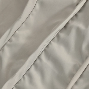 Vue détaillée de la texture sergée diagonale du tissu gris argenté et des coutures