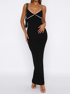 Detail of V-neck long black dress featuring delicate white lace trim and slim fit design