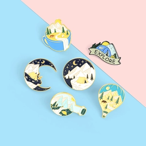 Detail of colorful enamel badges with mountain, tent and hot air balloon designs