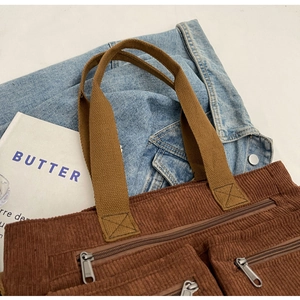 Detailed view of caramel corduroy tote bag with dual front pockets and silver zippers