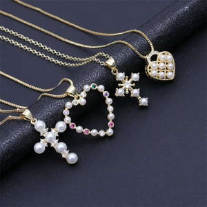 Detail of four golden necklaces featuring pearl crosses and rhinestone heart pendants
