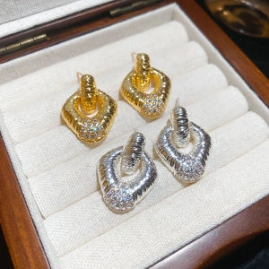 Dettaglio di orecchini a rombo in oro e argento con diamanti incastonati su velluto