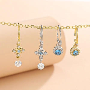 Cross and flower nose rings with blue gemstones and diamonds in gold and silver finishes