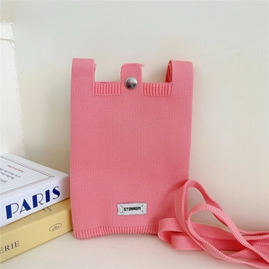Close-up of pink knit phone bag showing silver metal snap button and brand label detail