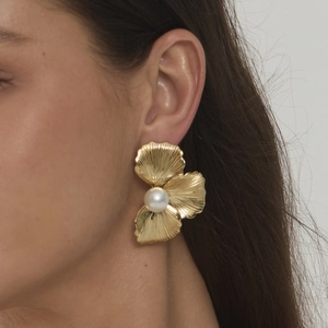 Elegant gold flower pearl earrings for women shown on model in a stylish side view