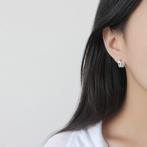 Puce d'oreille irrégulière en argent fin S925 avec texture ondulée portée par un mannequin