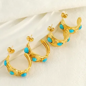 Créoles dorées vintage avec pierres turquoise et texture soleil sur fond blanc épuré