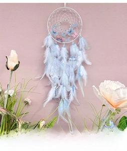 Detail view of light blue dream catcher with butterfly accents and soft hanging feathers