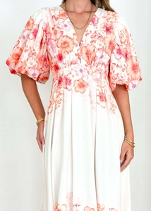 Detail of puff sleeves and V-neckline on white floral midi dress with orange-pink flowers
