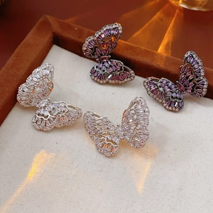 Macro detail of micro-paved butterfly earrings with purple and white cubic zirconia