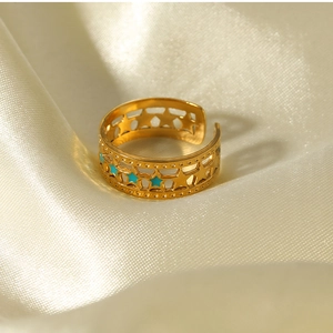 Detailed close-up of 18K gold-plated star ring with turquoise blue enamel on silk
