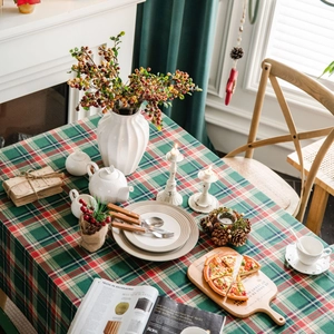 Green checkered farmhouse tablecloth with festive holiday dinner table setting and decor