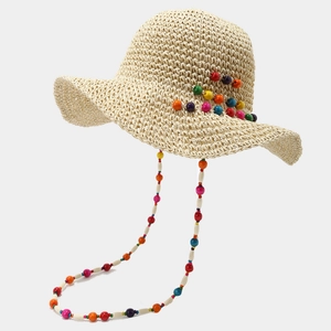 Détail d'un chapeau de paille bohème avec perles colorées et cordon de serrage décoratif