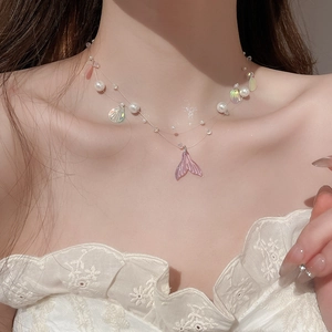 Detail of double-layer mermaid tail necklace with pink shell and white pearls on neck