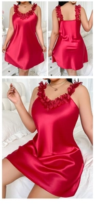 Détail d'une nuisette en satin rouge avec dentelle florale délicate sur le col et bretelles