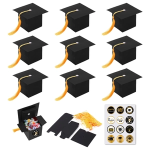 Detail of graduation cap candy boxes with yellow tassels and celebratory stickers set