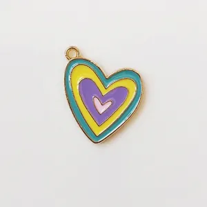 Macro view of multi-layered heart pendant with colorful enamel and gold-plated alloy