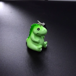 Cute green resin dinosaur keychain charm with realistic 3D details on textured background