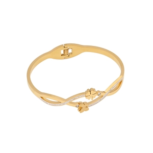 Gold stainless steel open bangle with sparkling clover and butterfly charms in 45-degree view