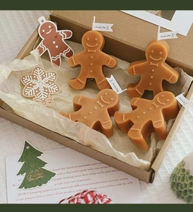 Detailed gift set of gingerbread man candles in a warm caramel brown festive packaging