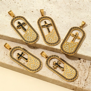 Golden Gothic cross pendants with skull motifs and zircon inlay on stone surface