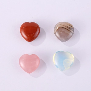 Polished heart-shaped natural stones in red jasper, rose quartz, agate and opal