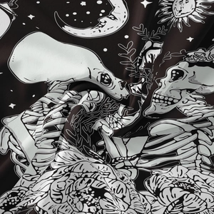 Close-up of black and white skull and moon phase patterns on soft polyester fabric