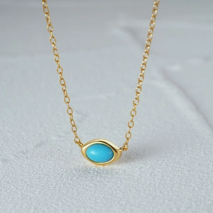 Macro shot of gold-plated S925 silver necklace with turquoise eye-shaped pendant