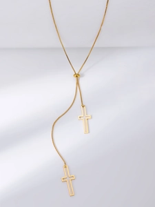 Detail view of adjustable 18K gold box chain with dual hollow cross pendants on white background