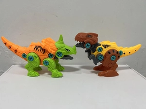 Detail of DIY take-apart dinosaur toy set with orange Triceratops and yellow T-Rex models