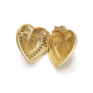 Detail view of an open 18K gold heart locket pendant showing textured inner compartments