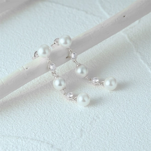 Macro detail of S925 sterling silver long tassel earrings with pearls and zircon stones