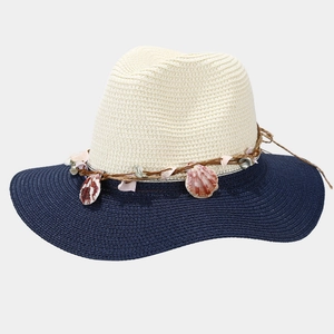 Detail of contrasting straw panama hat featuring natural shell band and navy blue wide brim