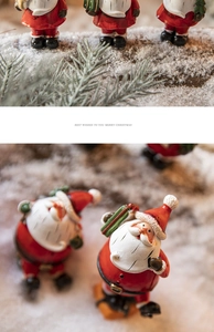 Macro detail of painted Santa Claus desktop ornaments in a winter snow setting