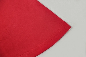Macro detail of red knitted A-line dress featuring high-quality double-needle stitching